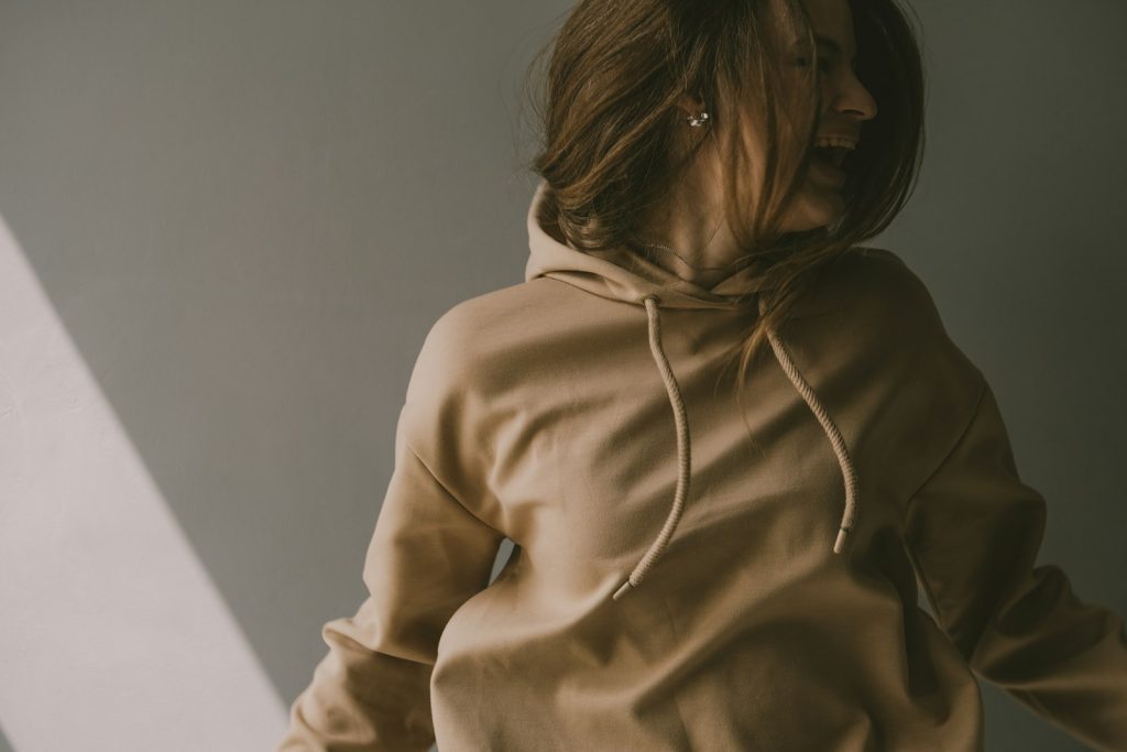 Model wearing a plain tan hoodie