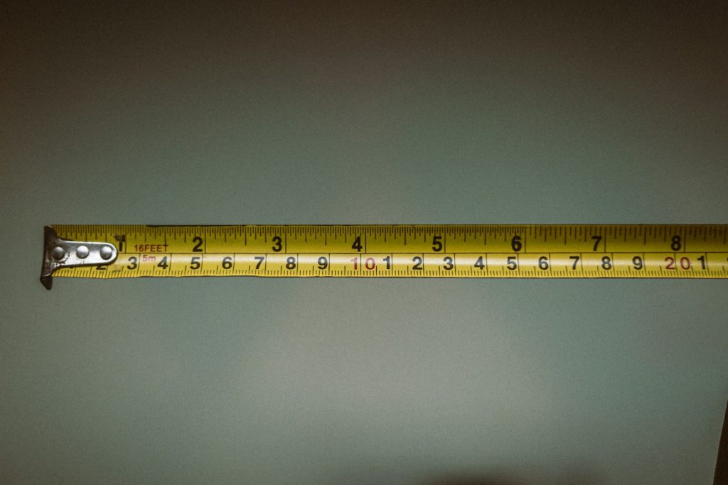 Tape measure held across a dark backdrop