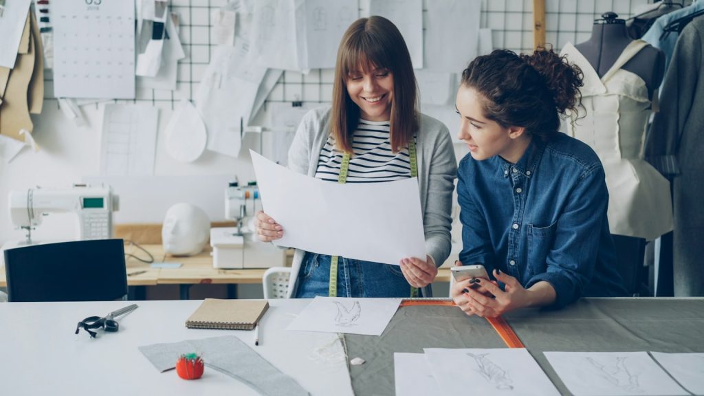 Two fashion designers reviewing a clothing pattern